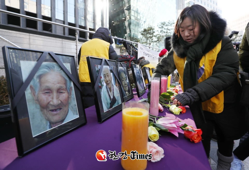 27일 오후 서울 종로구 구 주한일본대사관 앞에서 열린 '일본군 위안부 문제 해결을 위한 정기 수요시위'에서 정대협 관계자들이 올 한해 돌아가신 일본군 위안부 피해 할머니들의 영정 앞에 초와 꽃을 놓고 있다.