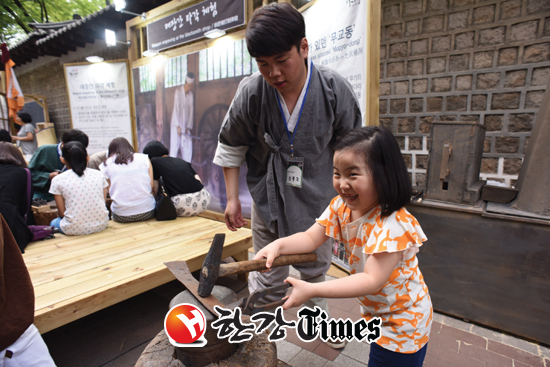 정동야행 축제에서 가족과 나들이를 나온 한 어린아이가 대장각 타각 체험을 하며 즐거워 하고 있다.