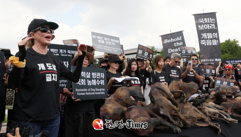 개 사육 농민 단체인 대한육견협회 회원들이 초복인 12일 서울 여의도 국회 앞에서 열린 기자회견에서 개 식용 금지 법안 반대를 주장하며 개고기 시식 퍼포먼스를 하고 있다. 사진=뉴시스