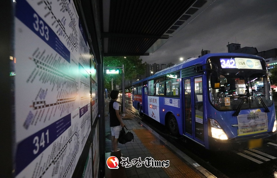 신종 코로나바이러스 감염증(코로나19) 확산 방지를 위해 오후 9시 이후 서울 지역 시내버스 운행횟수 감축 시행을 하루 앞둔 30일 오후 서울 송파구 잠실새내역 인근 버스 정류장에서 한 시민이 버스에 탑승하고 있다.