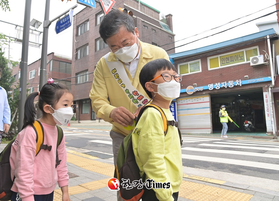 등굣길 어린이 가방에 교통안전형광카드를 달아주고 있는 서양호 중구청장