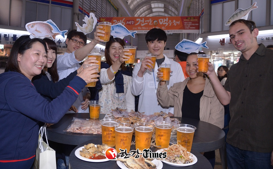 '2016년 제1회 건어물 맥주 축제'에서 행사장을 찾은 외국인과 시민들이 맥주와 건어물 안주를 들고 건배하고 있다.
