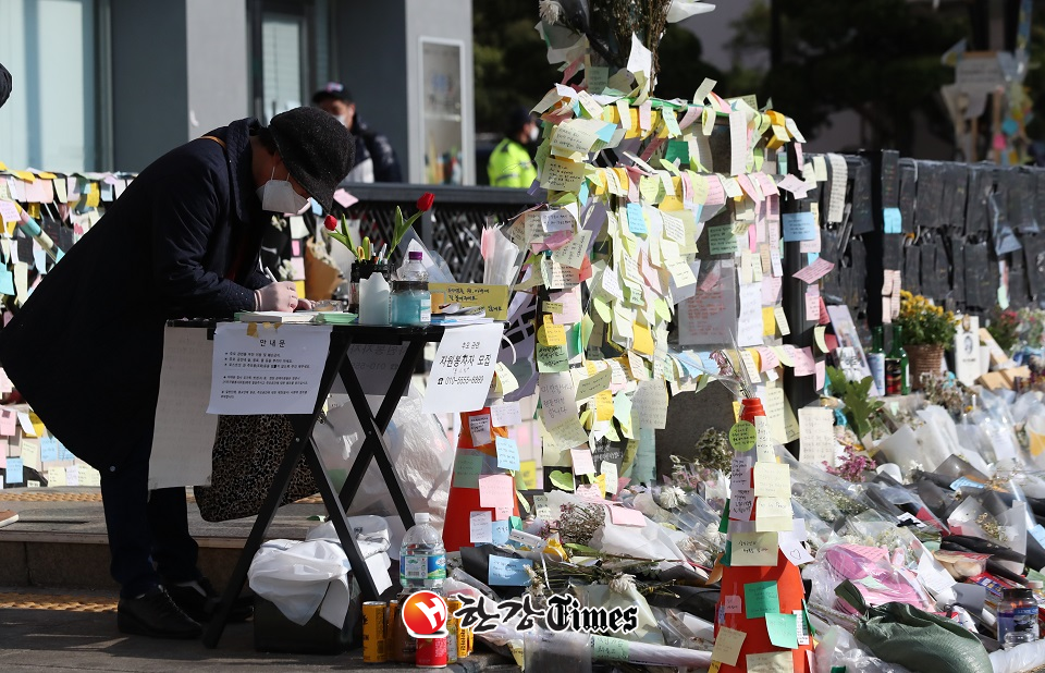 이태원 참사 발생 이후 사고 거리 통행이 재개된 가운데 12일 오전 서울 용산구 이태원 거리 인근에서 한 시민이 추모글을 작성하고 있다. (사진=뉴시스)
