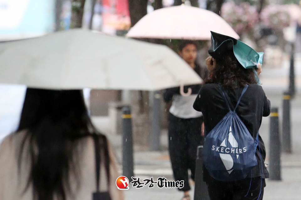비가 내리는 18일 오후 서울 신촌 거리에서 한 시민이 가방을 머리에 쓰고 이동하고 있다. (사진=뉴시스)