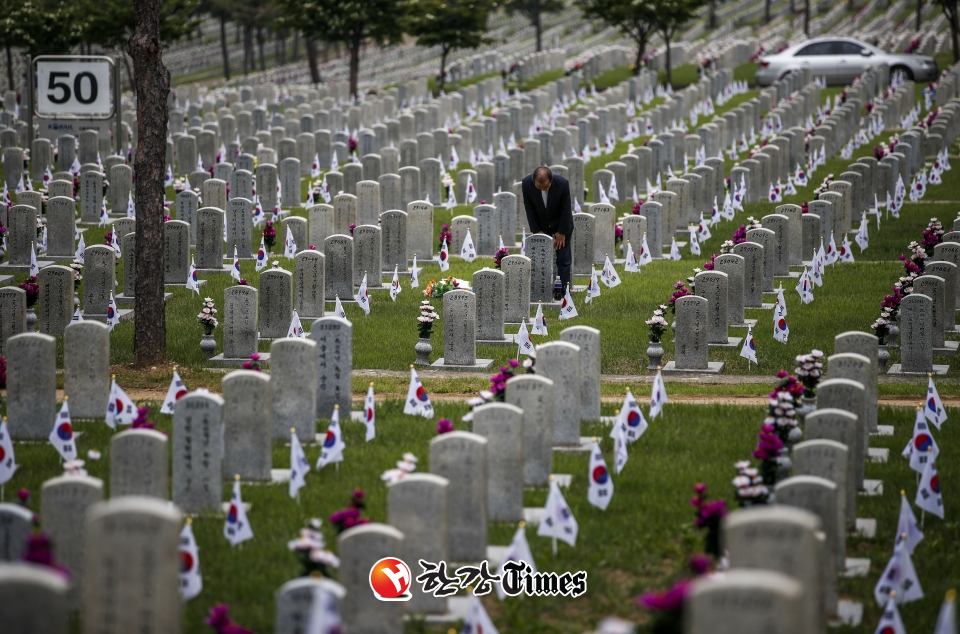 호국 보훈의 달 첫 날인 1일 오전 서울 동작구 국립서울현충원을 찾은 시민이 전사자의 묘 앞에서.묵념하고 있다.
