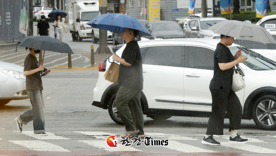 전국적으로 장맛비가 내리기 시작한 26일 전북 전주시 백제대로에서 시민들이 우산으로 비를 피하며 길을 지나고 있다.
