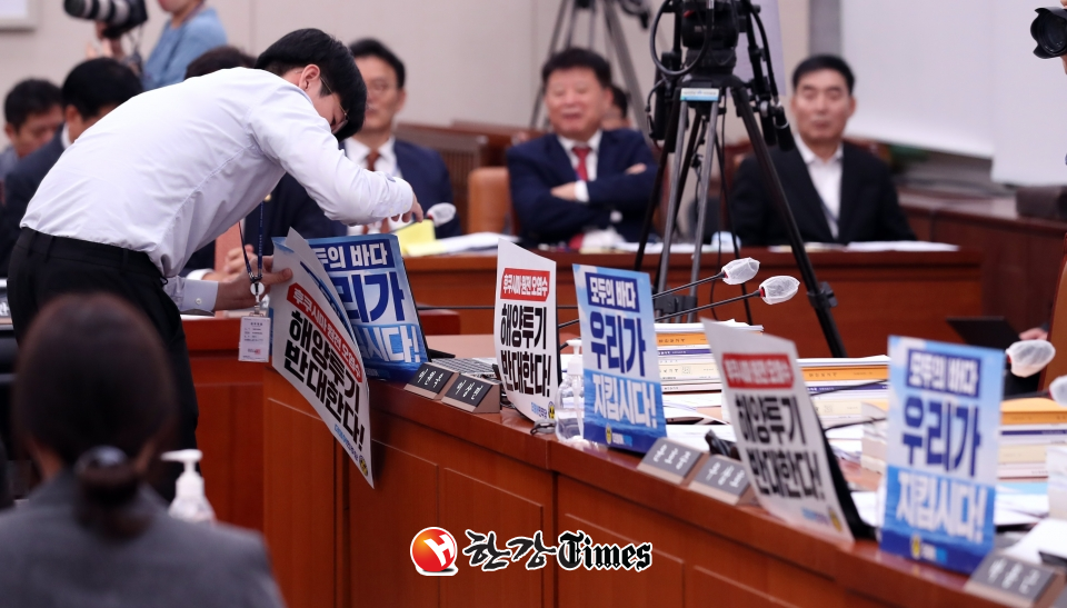 민주당 의원실 관계자가 23일 오전 서울 여의도 국회에서 열린 외교통일위원회 전체회의에서 피켓을 제거하고 있다. (사진=뉴시스)