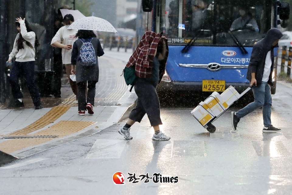 비가 내리고 있는 지난 4일 오후 서울 명동성당 인근 거리에서 우산을 챙기지 못 한 시민들이 황급히 이동하고 있다. (사진=뉴시스)